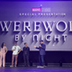 standing on stage with logo in back